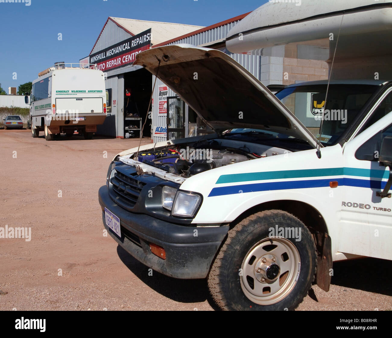 Four-wheel drive vehicle (4WD or AWD) with open bonnet or popped hood in front of garage repair shop, Western Australia, Austra Stock Photo