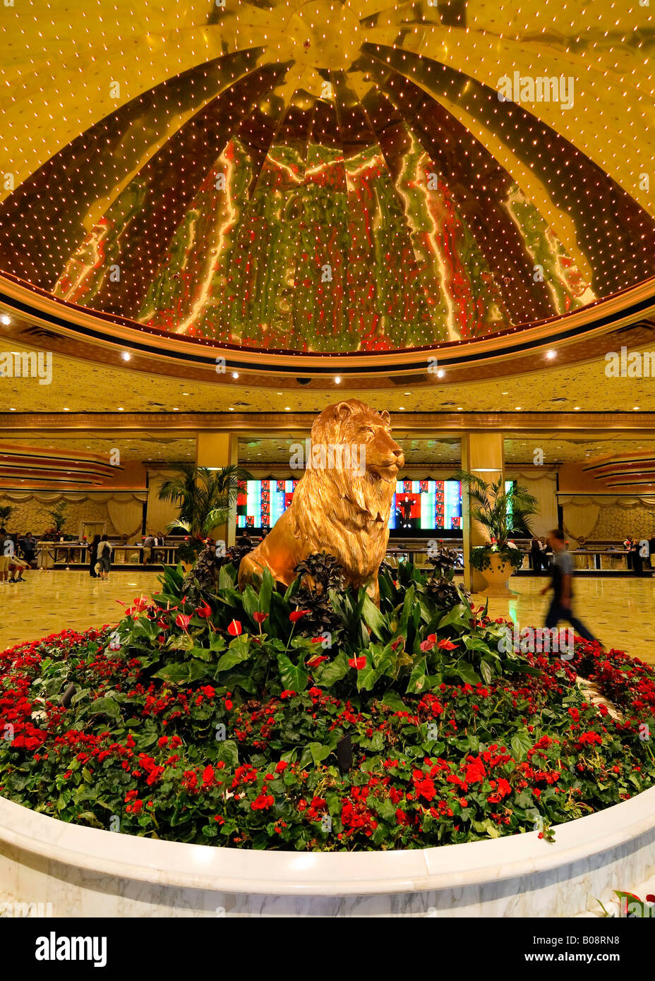 Statue of a golden lion surrounded by red flowers under a golden dome in the lobby of the MGM Grand Hotel and Casino, Las Vegas Stock Photo