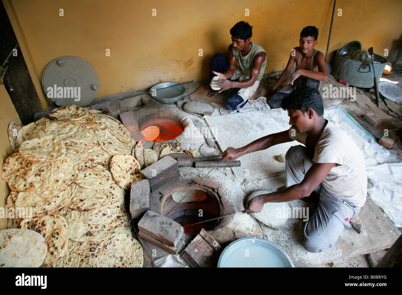 Man taking naan bread out of an oven, Bareilly, Uttar Pradesh, India, Asia Stock Photo