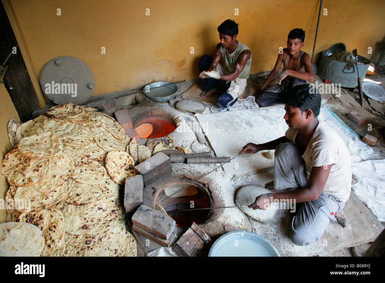 Man taking naan bread out of an oven, Bareilly, Uttar Pradesh, India, Asia Stock Photo