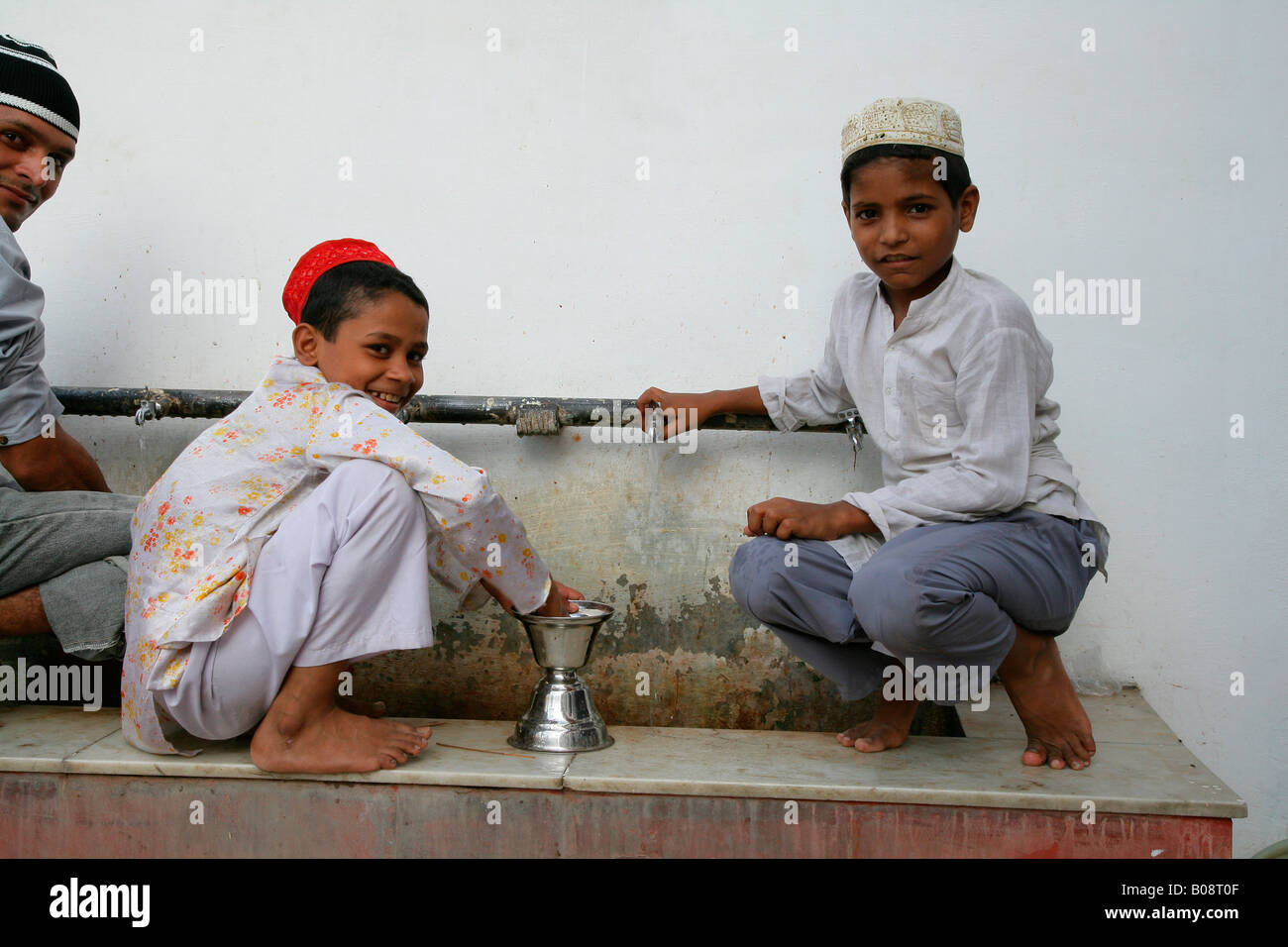 Boys cleaning ritual objects used at a shrine, Bareilly, Uttar Pradesh, India, Asia Stock Photo