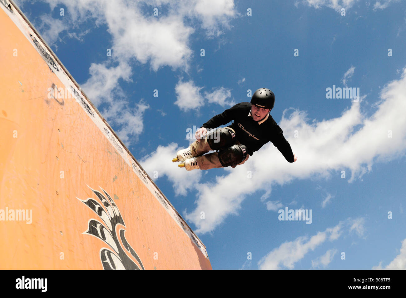 https://c8.alamy.com/comp/B08TF5/inline-skater-or-roller-blader-jumping-from-half-pipe-B08TF5.jpg