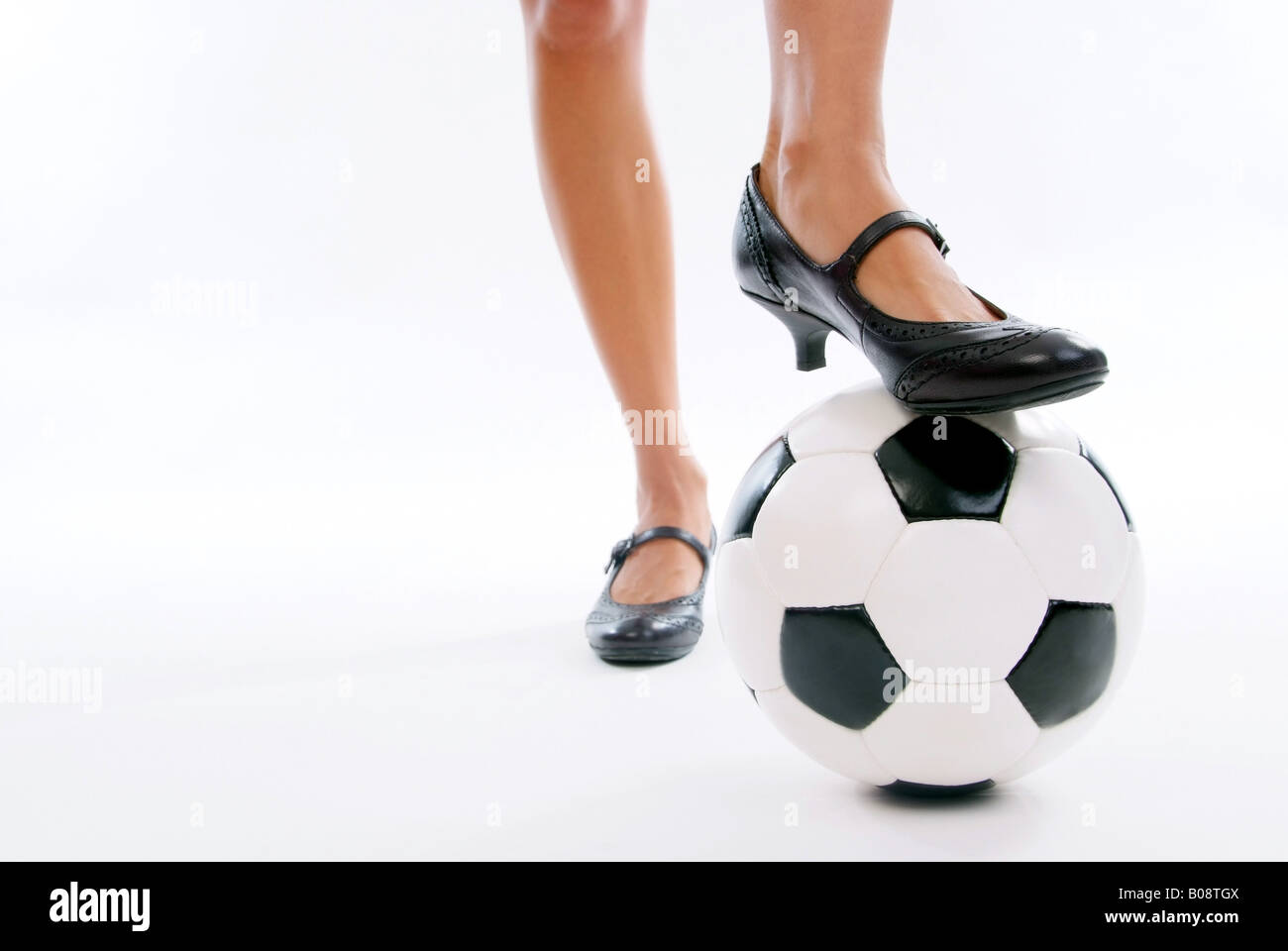 woman legs in high heeled shoes with soccer ball Stock Photo