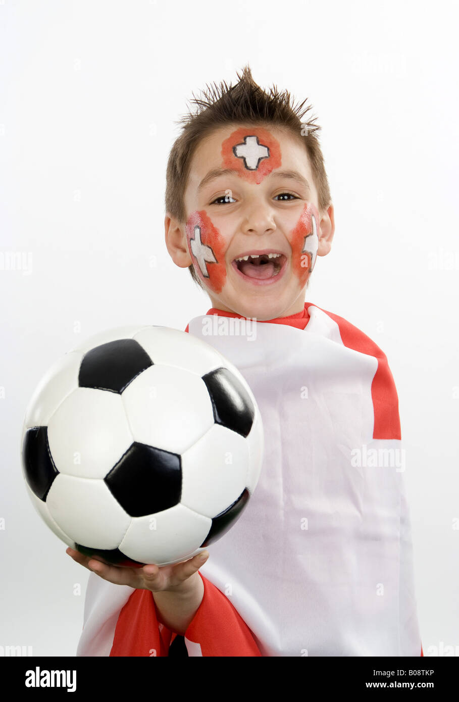 boy, rouged as Swiss soccer fan, with football in his hand and flag Stock Photo