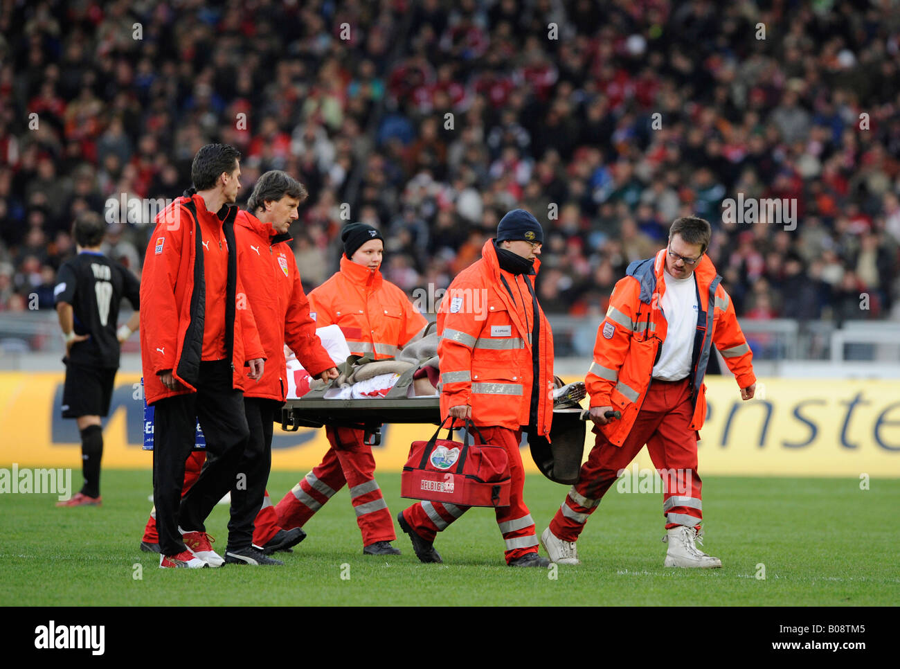 Paramedics carrying an injured football player on a stretcher Stock Photo