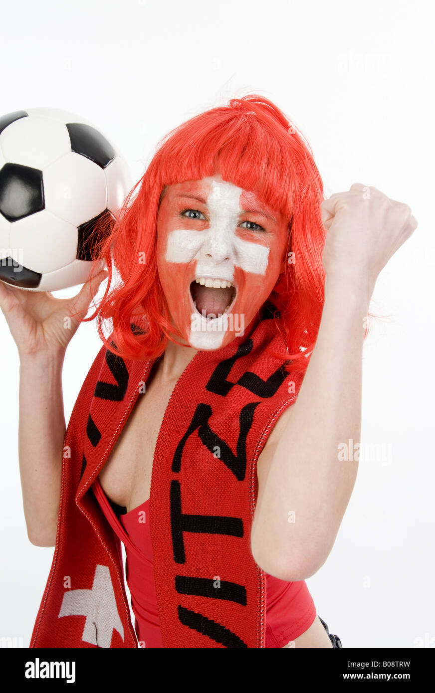 woman as Switzerland fan, cheering with a football and clenched fist Stock Photo