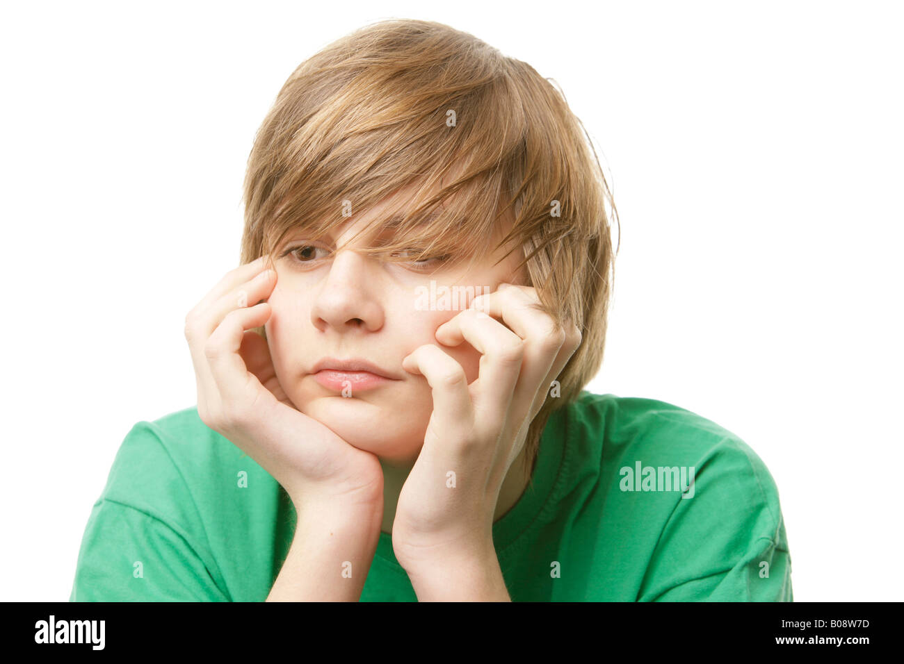 13-year-old boy wearing a green t-shirt resting his chin on his hands Stock Photo