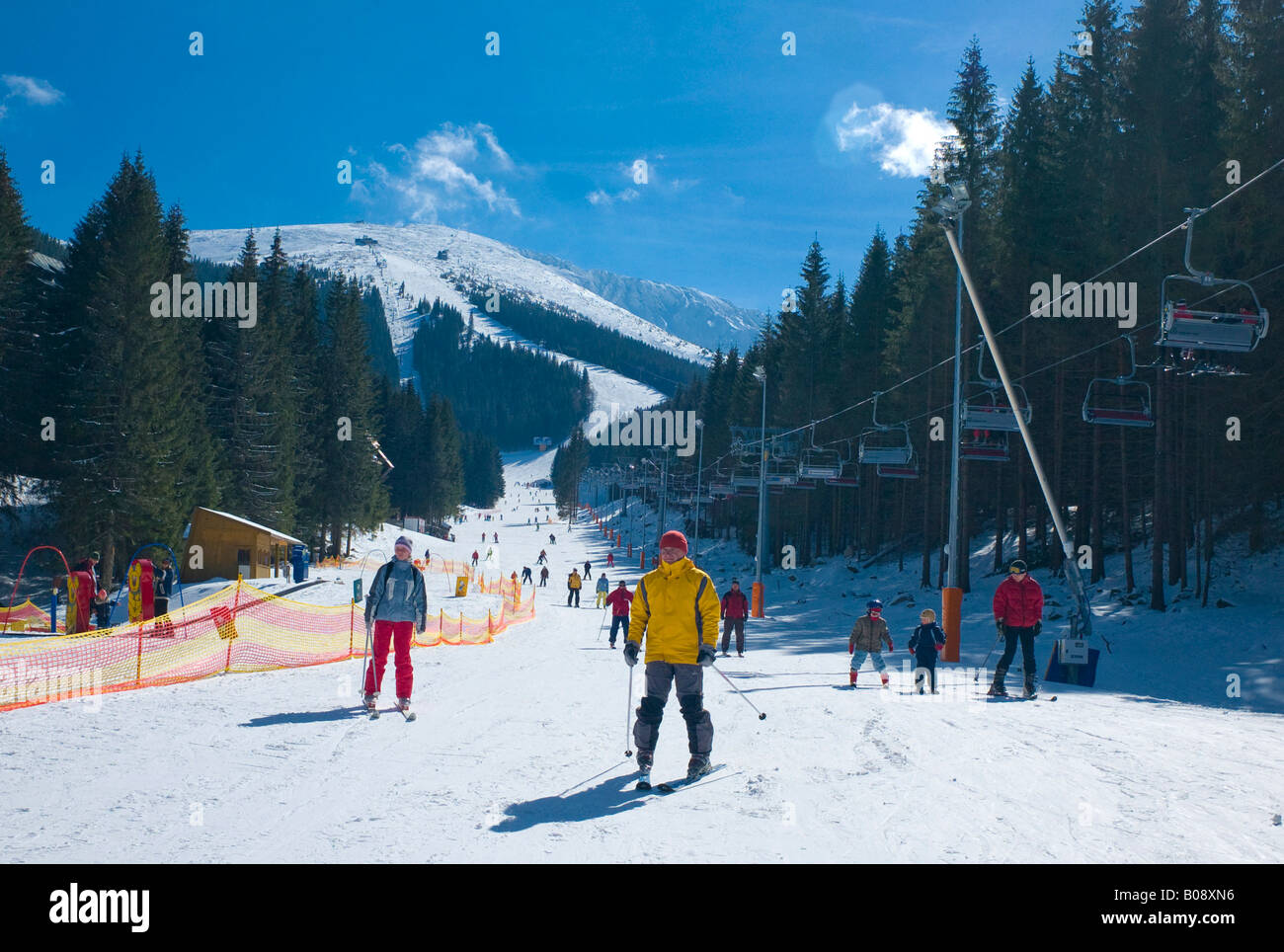 Skiers skiing down the Lukova ski run, Jasna Ski Resort, Lower Tatras, Slovakia Stock Photo