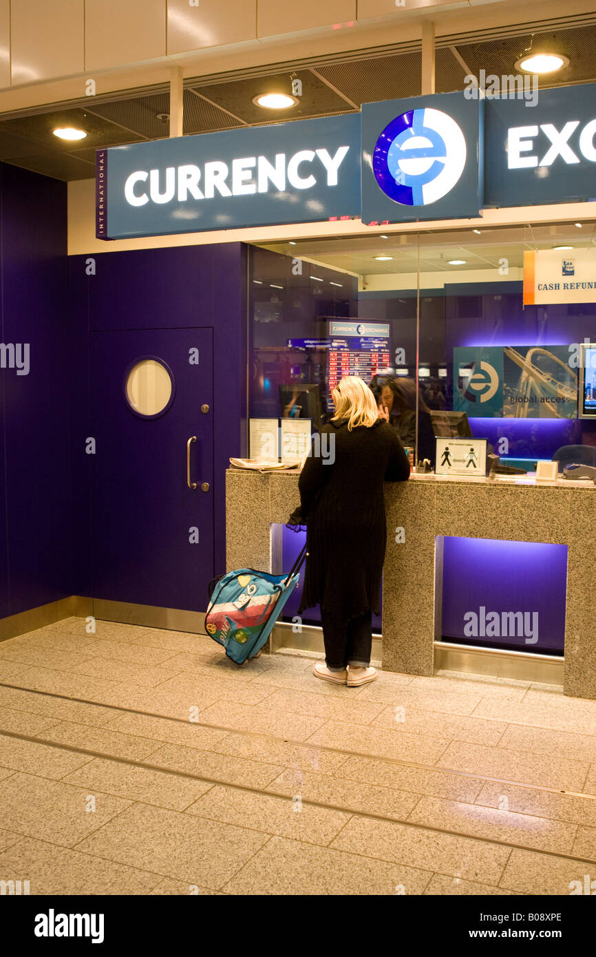 Young woman changing money at a currency exchange counter, Frankfurt International Airport, Hesse, Germany Stock Photo