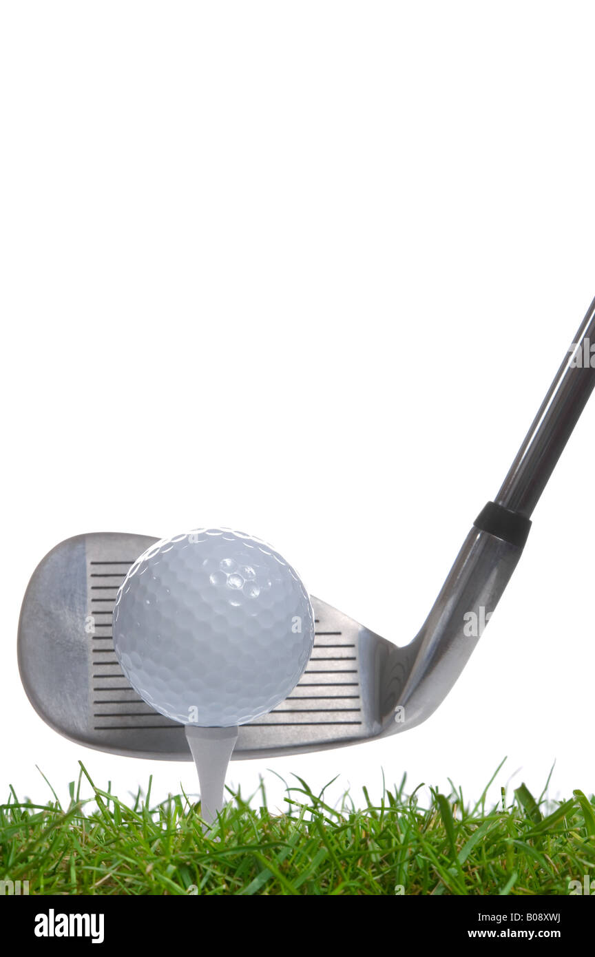 Close up of a golf ball on a tee with an iron club behind studio shot using real grass Stock Photo