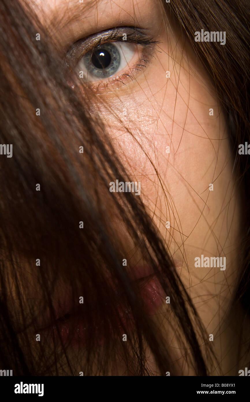 Portrait of a young dark-haired woman, hair falling over her face Stock Photo