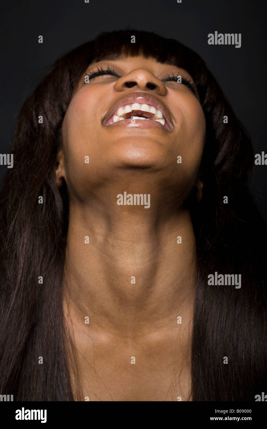Portrait of a young, laughing dark-skinned woman, her head back Stock Photo