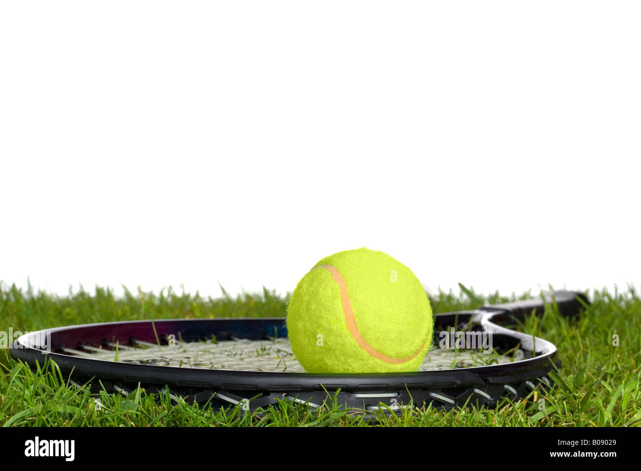 Surface level shot of a tennis racket and ball on real grass Stock Photo