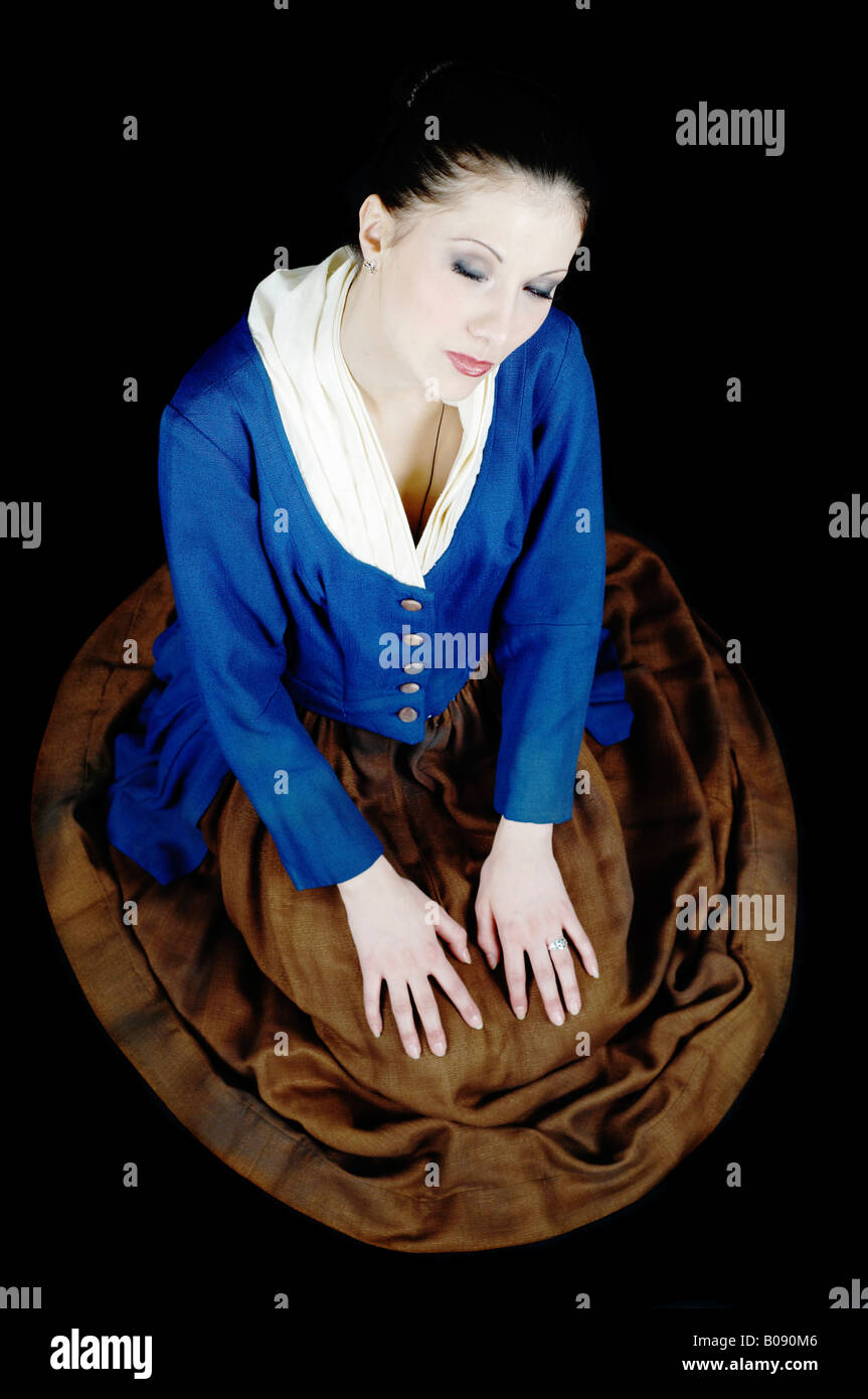 Young ballet dancer kneeling on the floor, wearing an old fashioned costume Stock Photo