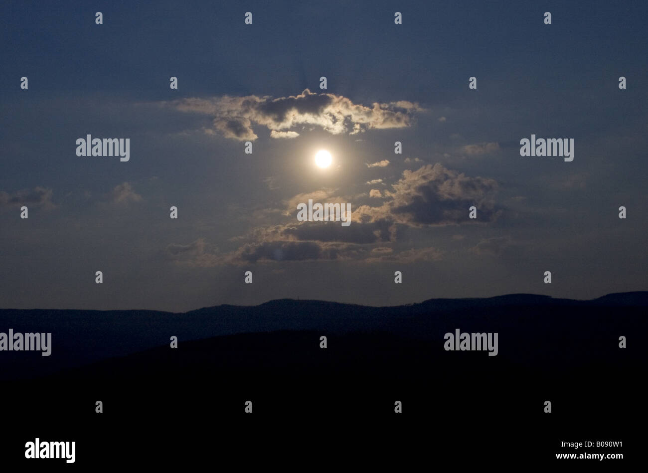 Moon between clouds over the Black Forest, Germany, Baden-Wuerttemberg Stock Photo