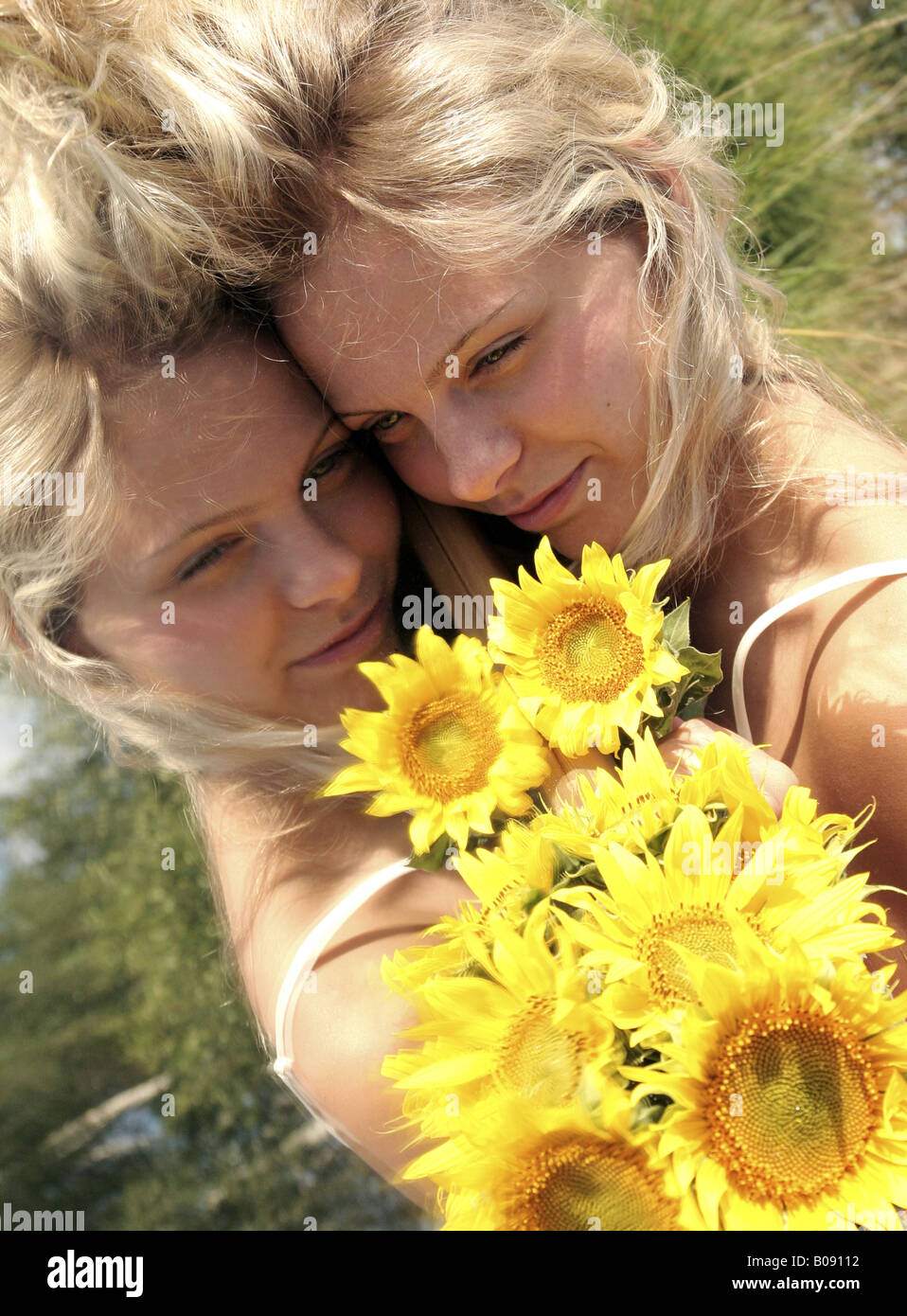 Portrait Of A Joung Fair Haired Women Lying On A Mirror With Sunflowers In The Garden Stock 