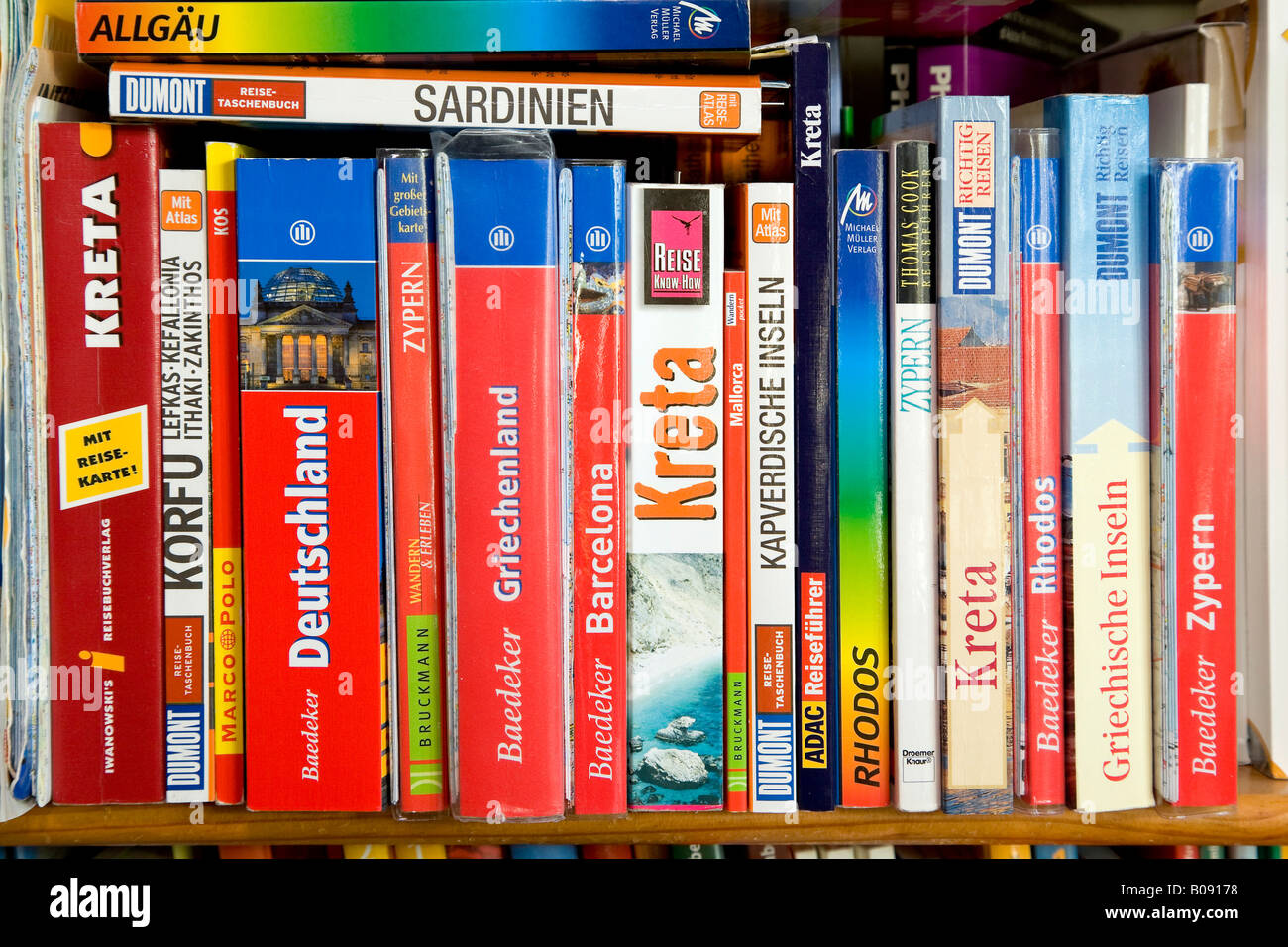 Various travel guides on a bookshelf Stock Photo