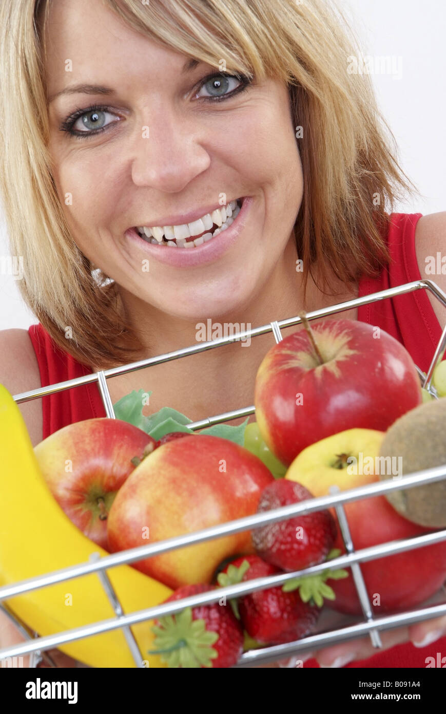 blond woman with a basket with fruits, smiling Stock Photo - Alamy
