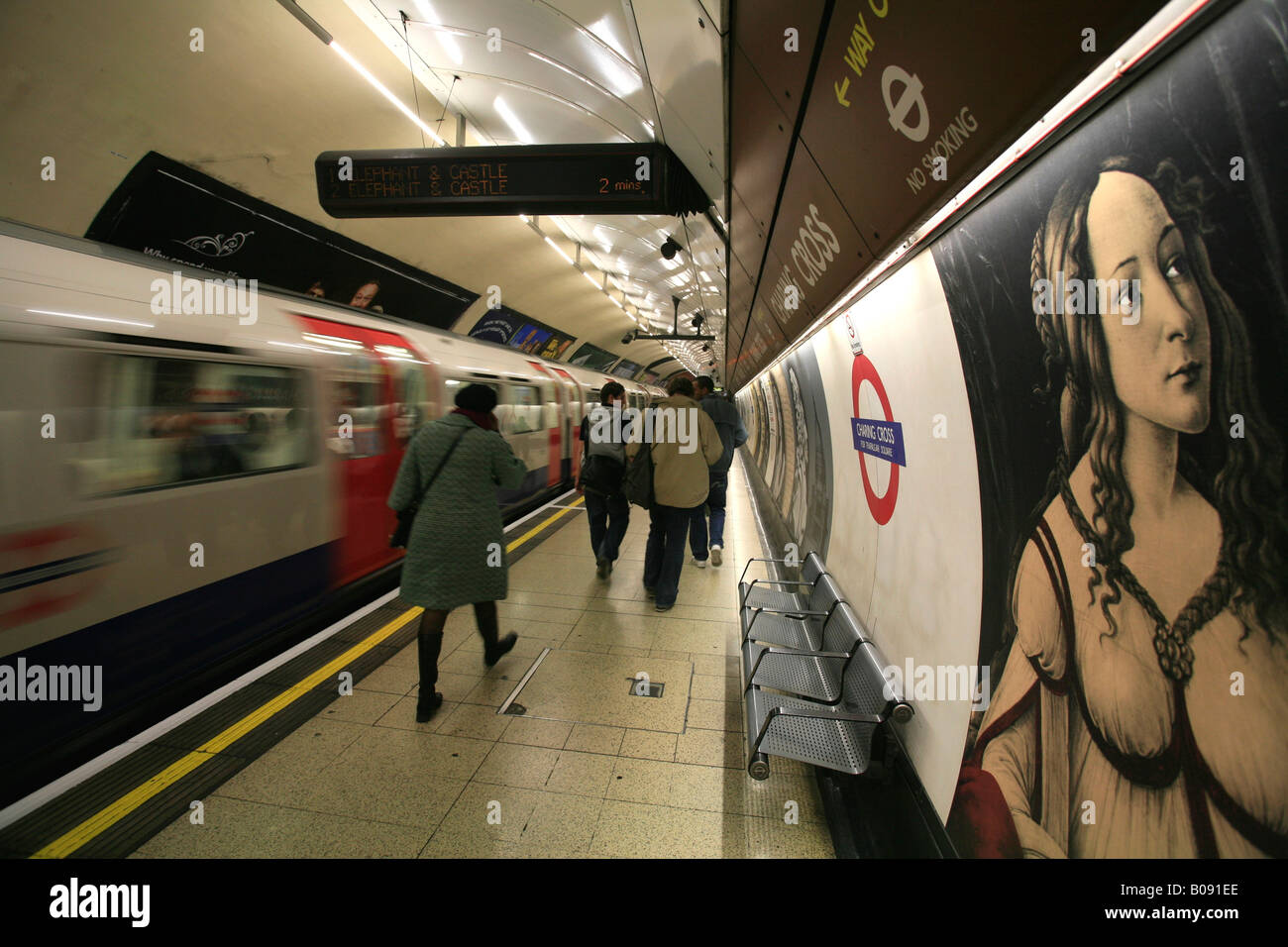 Art inside Charing Cross tube station, London Underground logo and passing train, London, England, UK Stock Photo