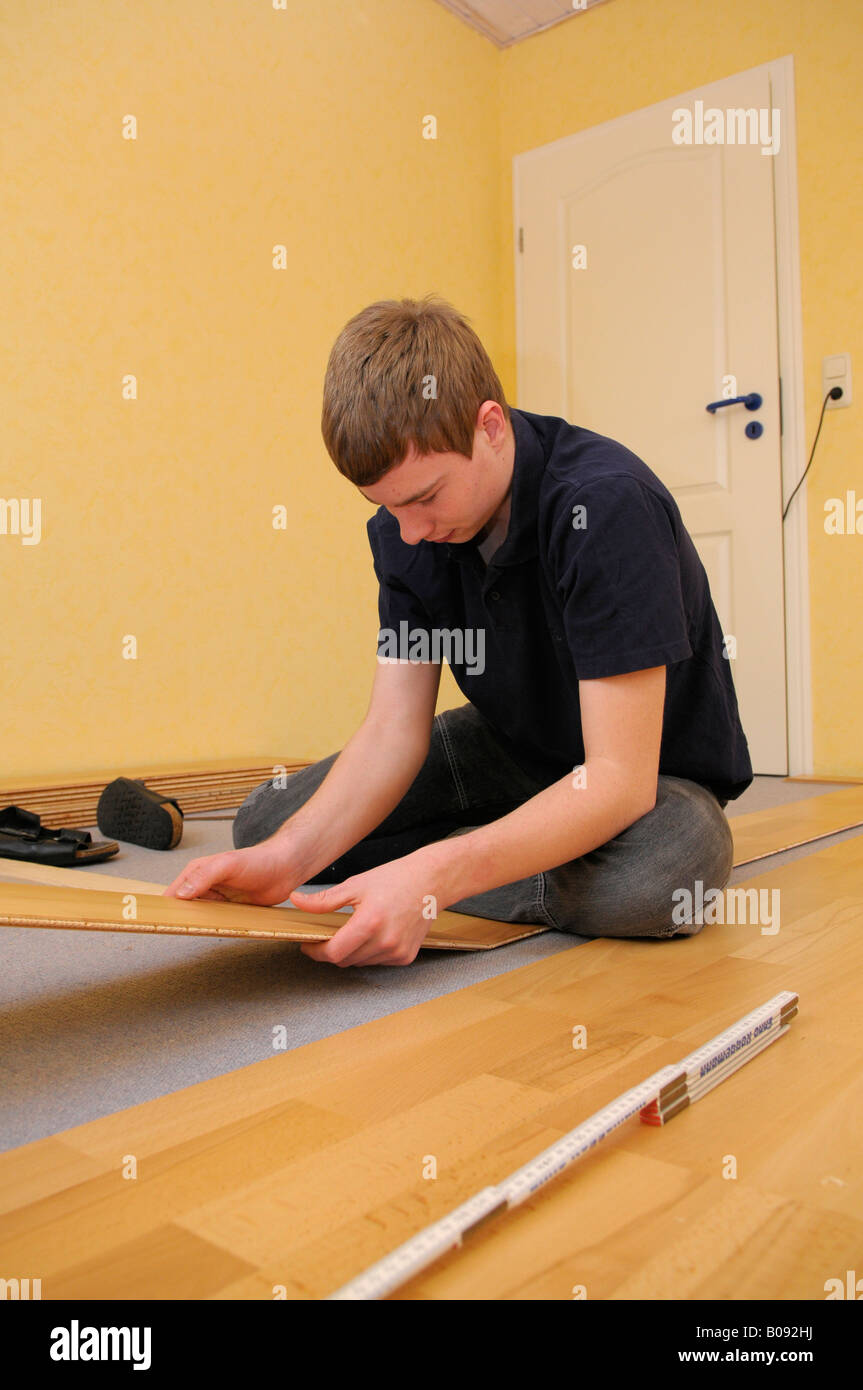 Teenager laying parquet flooring Stock Photo