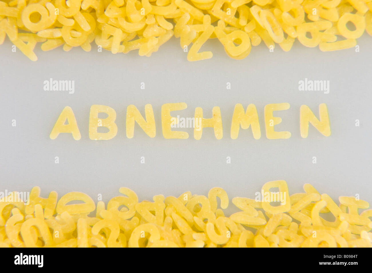 'Abnehmen' (lose weight) written in noodle letters, pasta alphabet Stock Photo