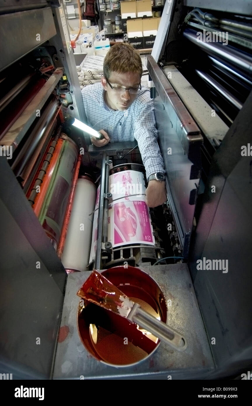 Man checking a litho printing machine in a Kall Kwik shop. Stock Photo