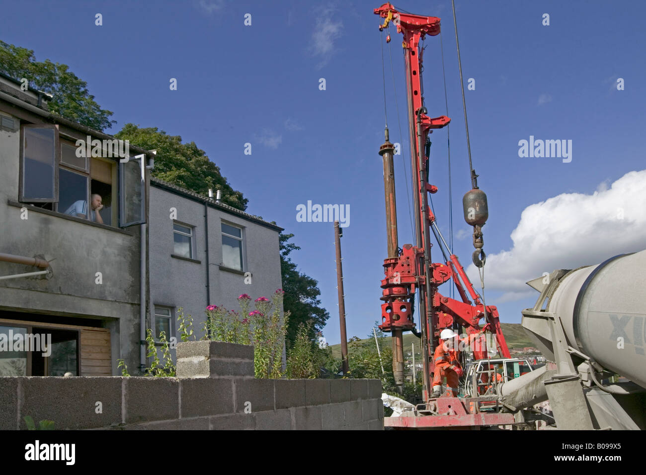 Piling rig excavating foundations for new road in close proximity to homes and businesses close to town centre in South Wales. Stock Photo
