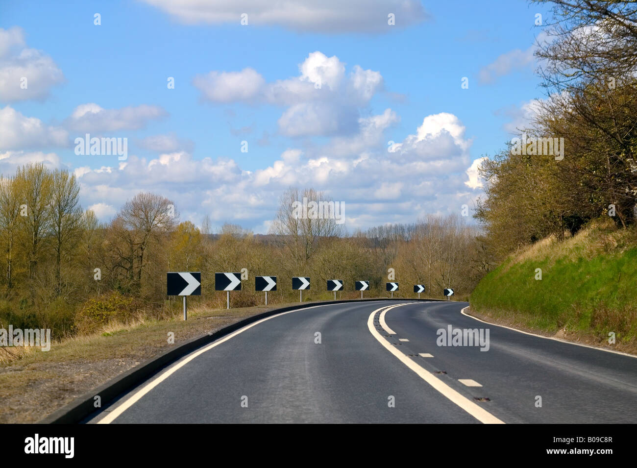 Approaching a sharp bend on a rural road with views of the countryside Stock Photo