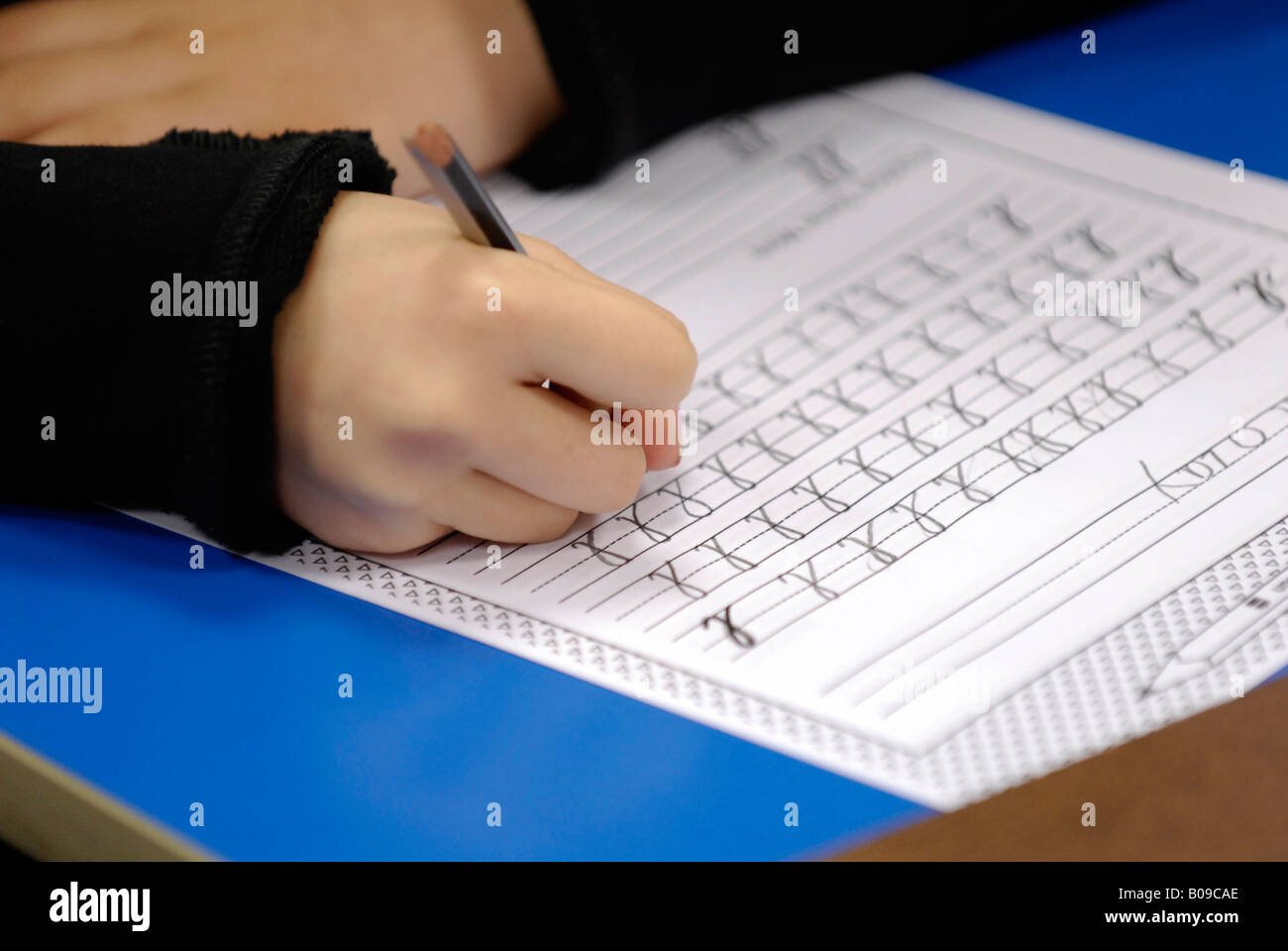 Close-up of young child's hand practicing handwriting Stock Photo