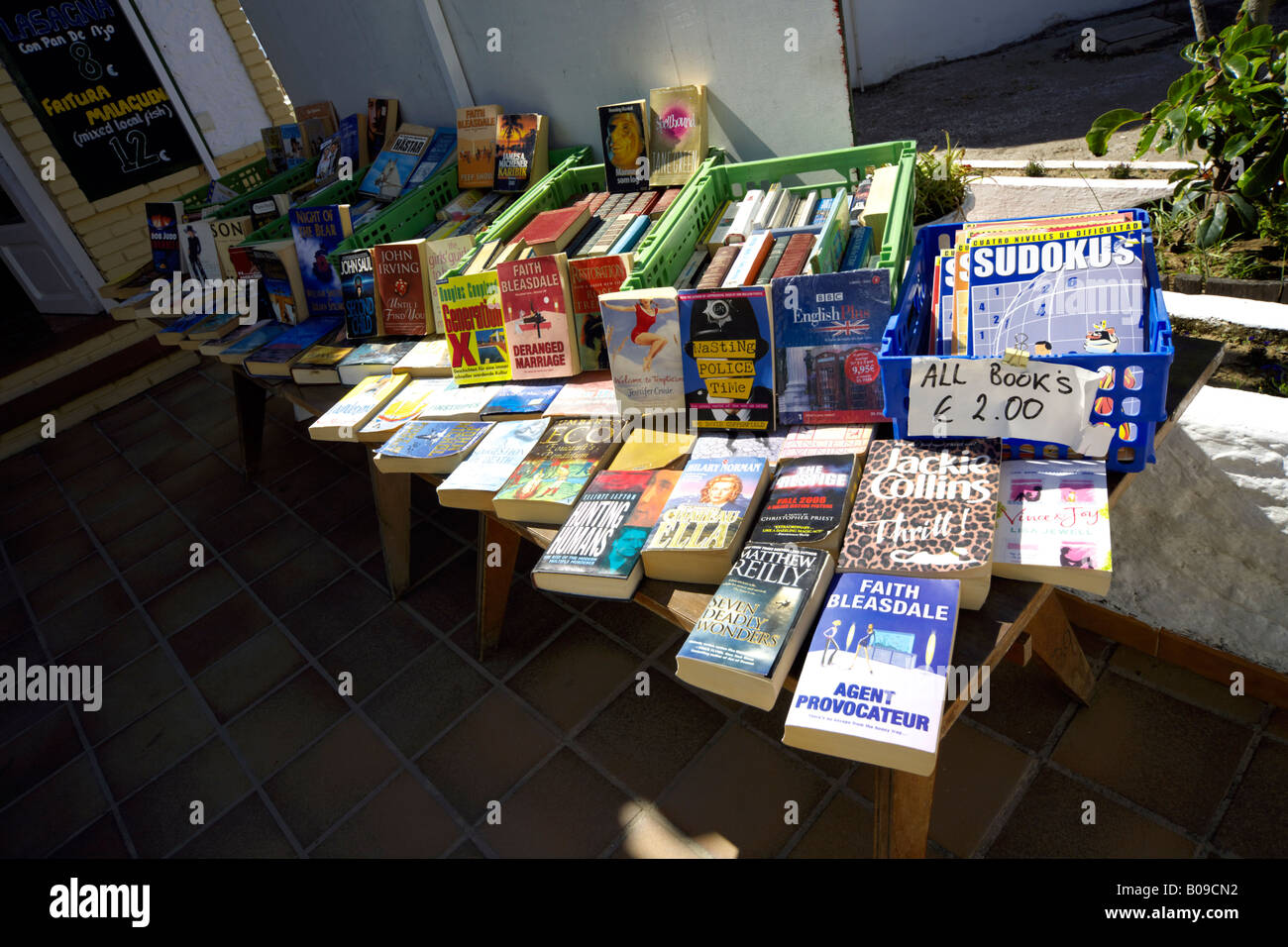 English language books for sale on a wooden table outside a beach restaurant in Torremolinos, Costa del Sol, Spain Stock Photo