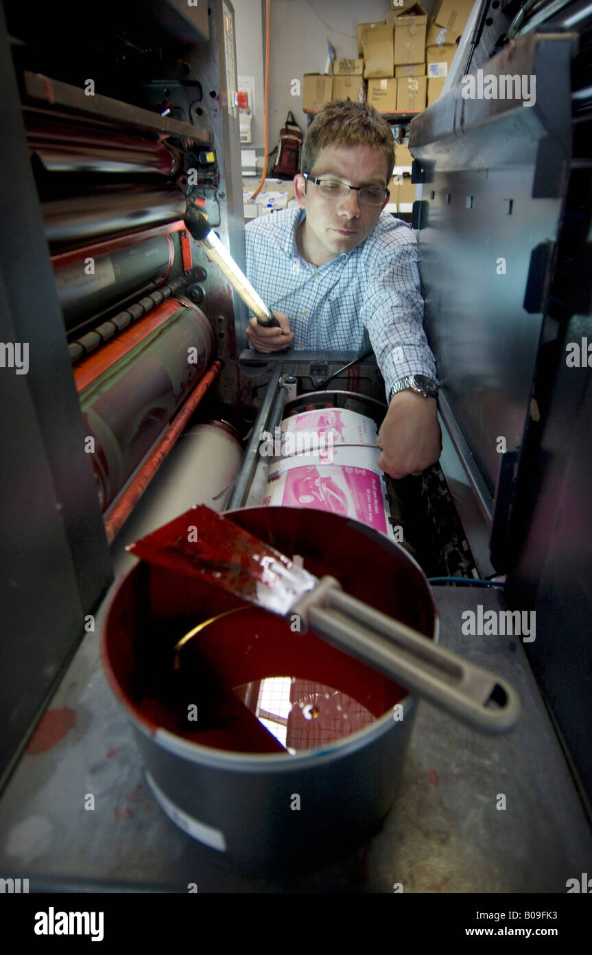 Man checking a litho printing machine in a Kall Kwik shop the franchised network of design, digital printing and copying centres Stock Photo