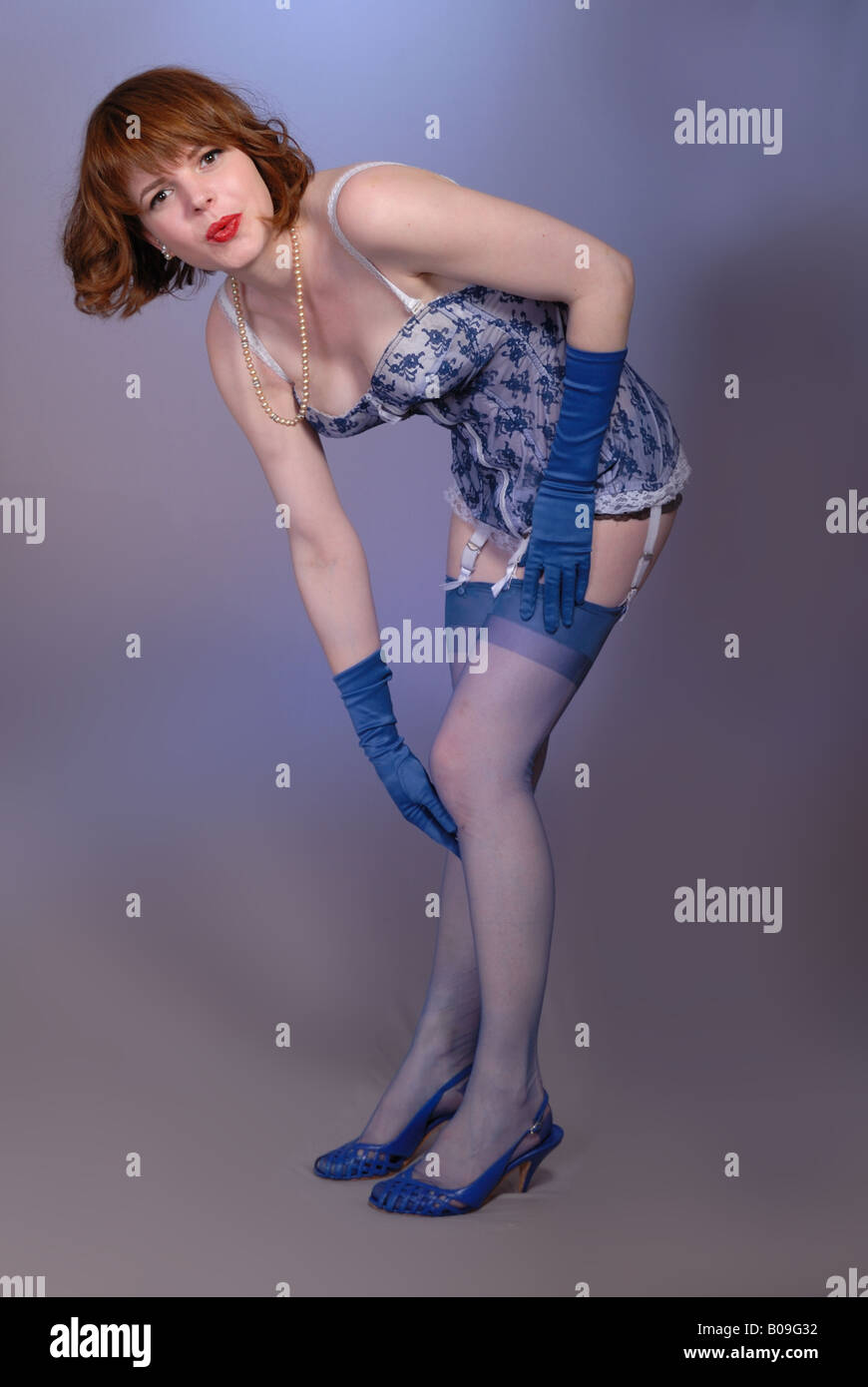 attractive retro fifties pinup girl in blue vintage lingerie and