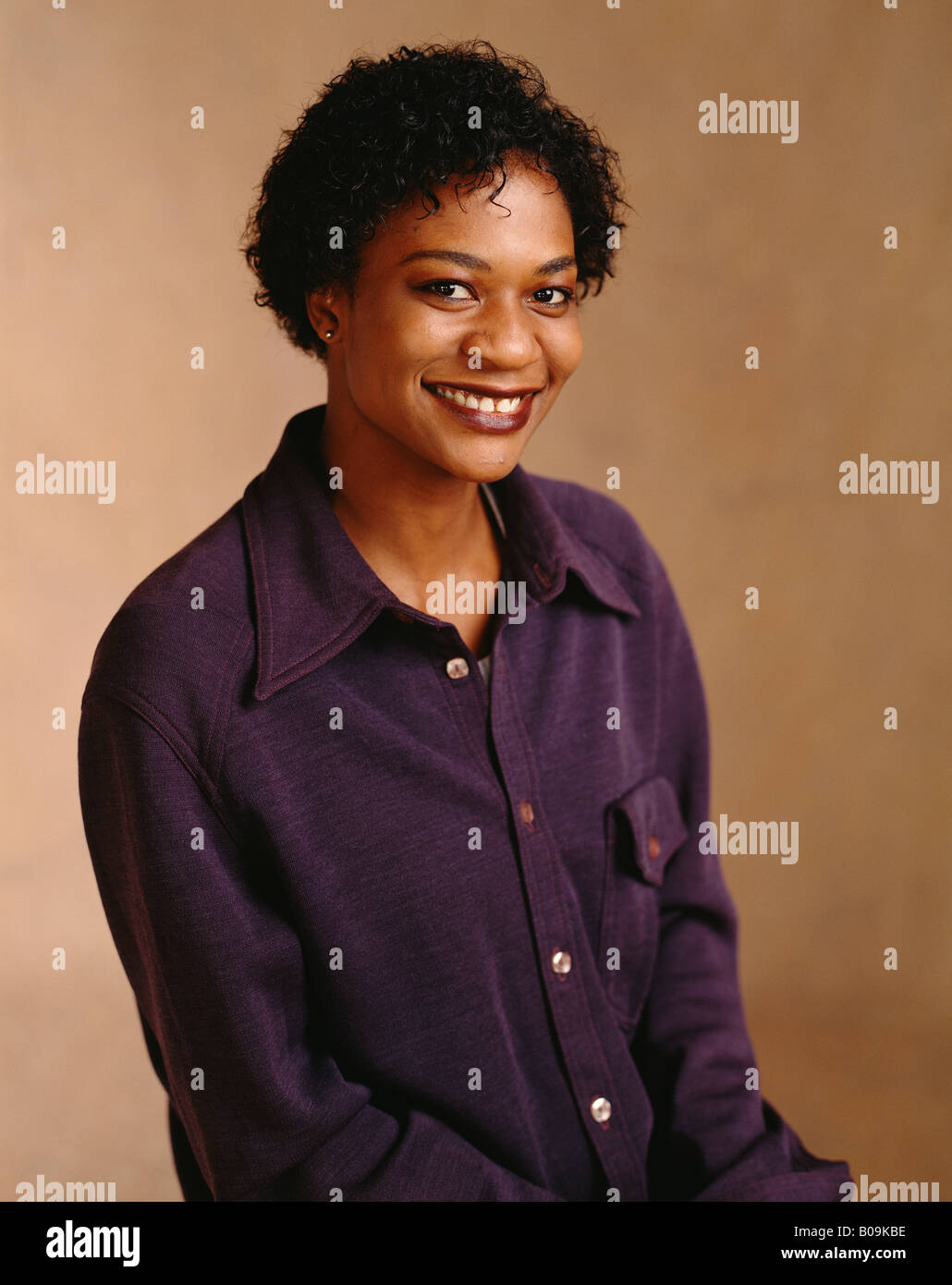 An African American woman in her thirties smiling for her portrait in a photo studio. Stock Photo