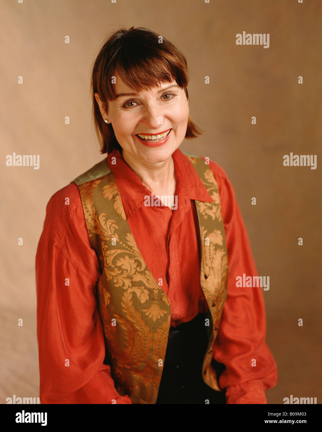A studio portrait of a woman in her forties smiling Stock Photo