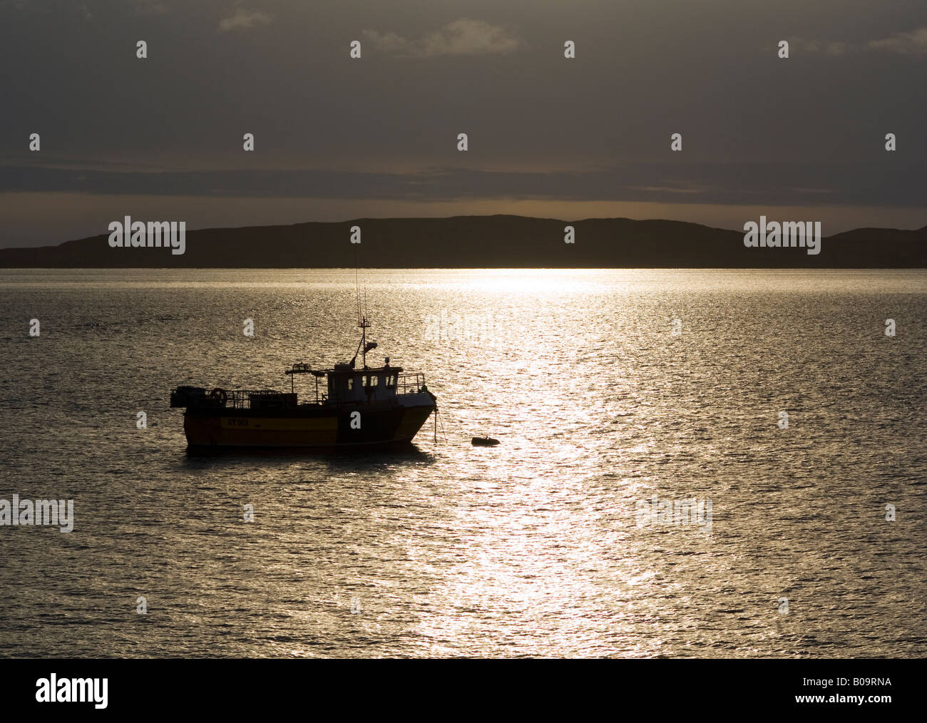 fishing boat at sunset taken from the beach at elgol skye Stock Photo