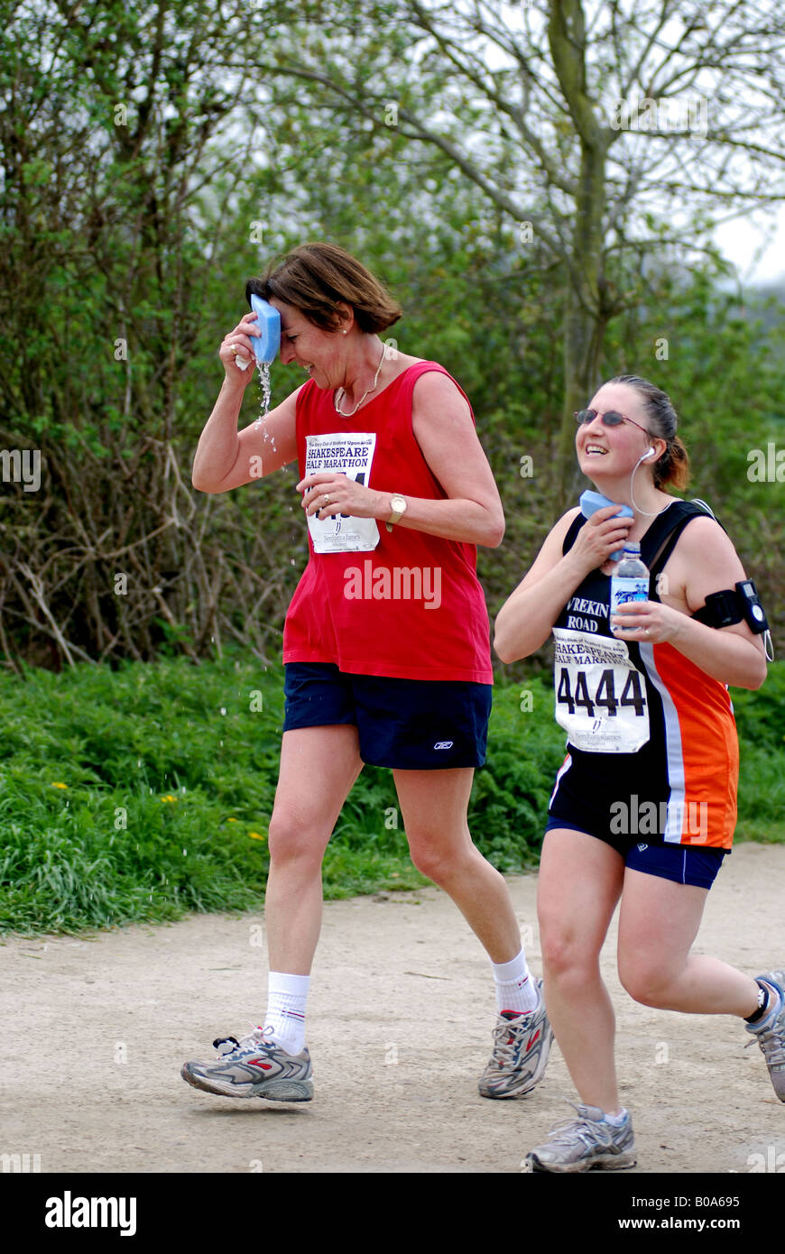 Women cooling down with wet sponges in half marathon race, UK Stock Photo