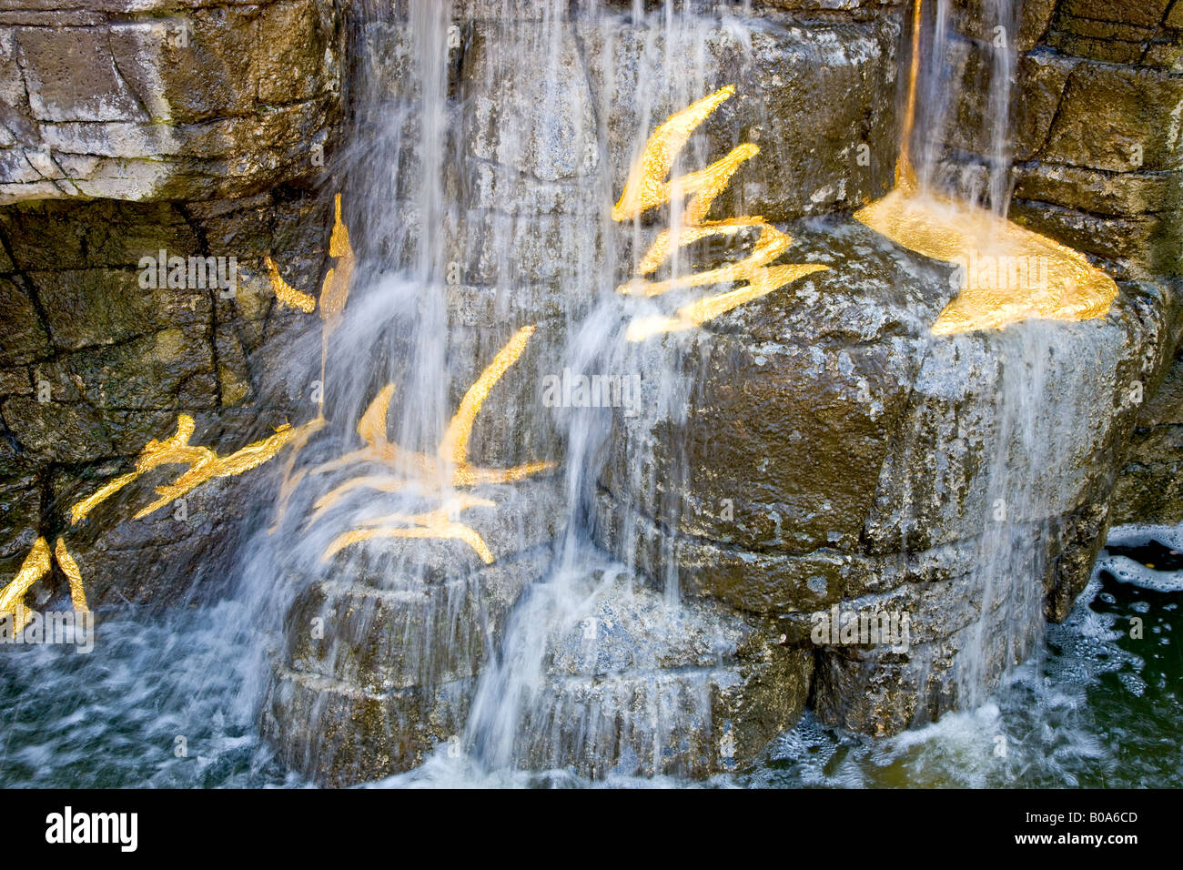 Gold painted rocks in the waterfall Stock Photo