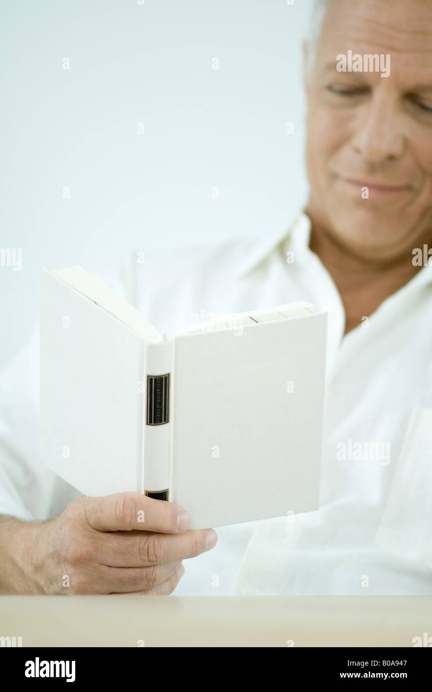Mature man reading book, cropped view Stock Photo
