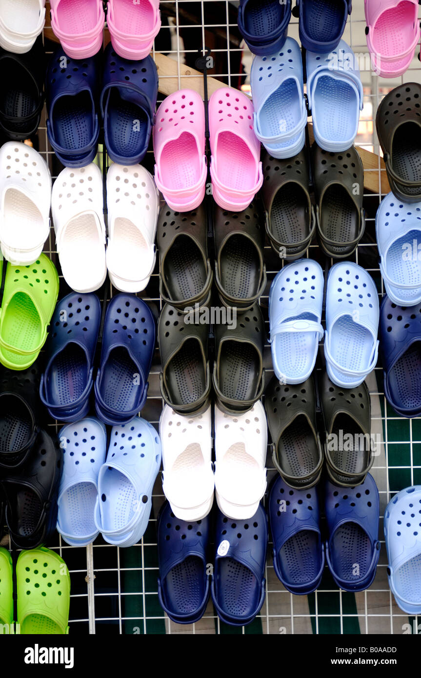A collection of clogs shoes hanging on a wall. Stock Photo