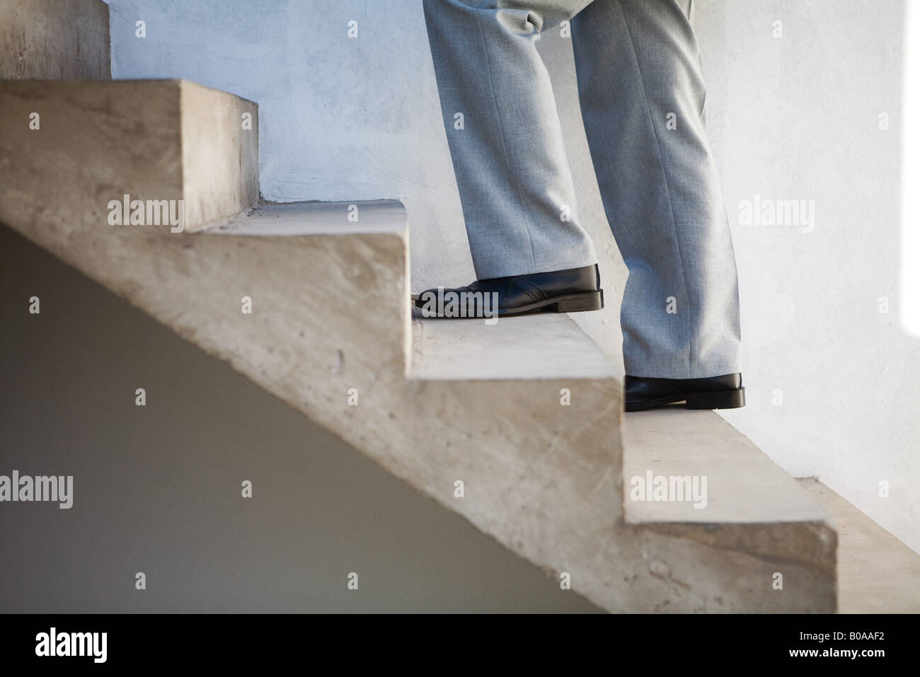 Man walking up staircase, side view, cropped Stock Photo