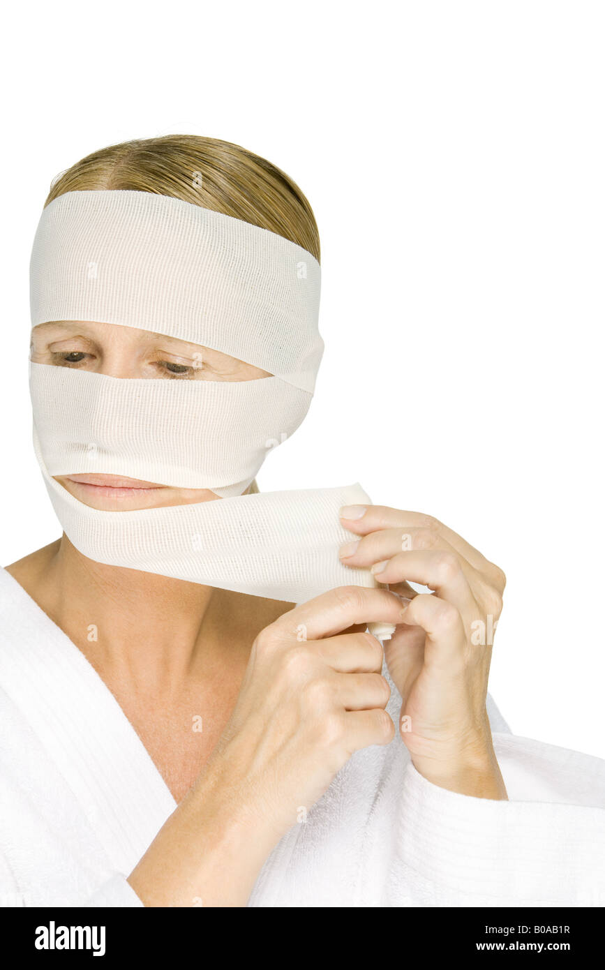 Woman removing bandages from face, looking away Stock Photo Alamy