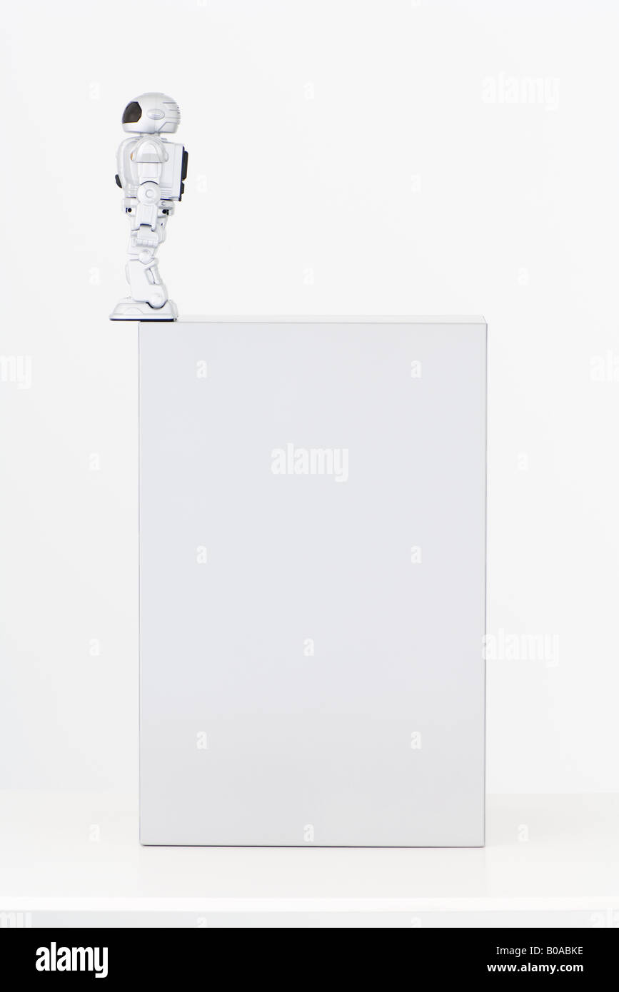 Robot standing on edge of box Stock Photo
