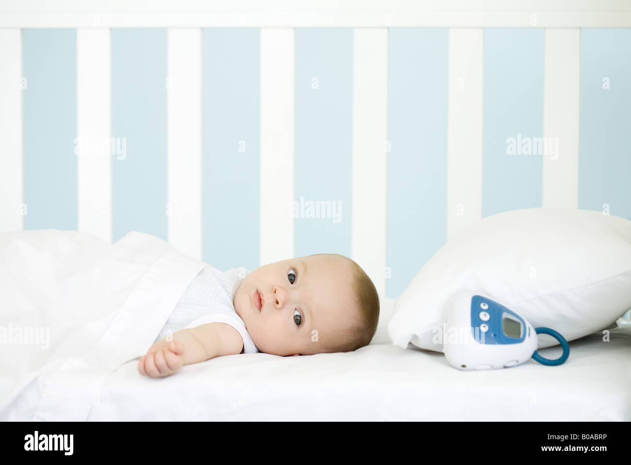 Infant lying in crib, looking at camera Stock Photo Alamy