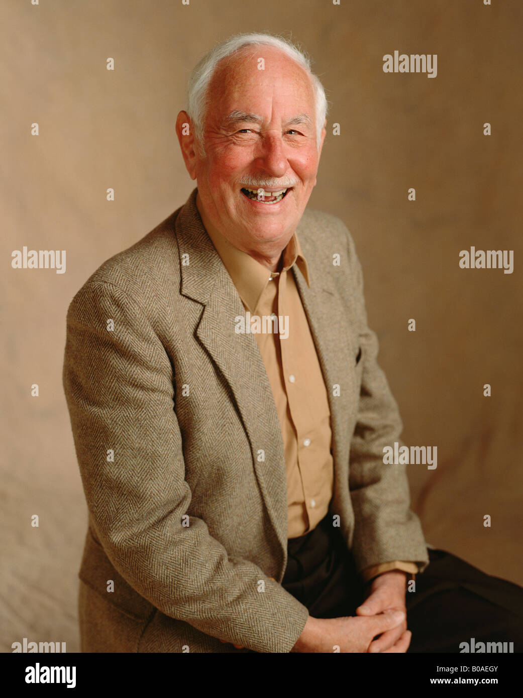 An senior male sits for his portrait with a big smile. Stock Photo