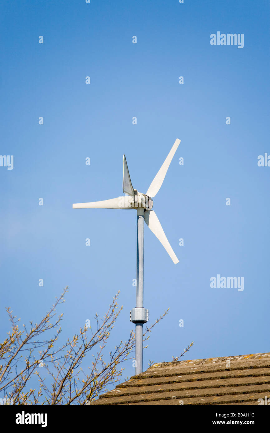 Windsave micro wind turbine mounted on house above roof with blue sky