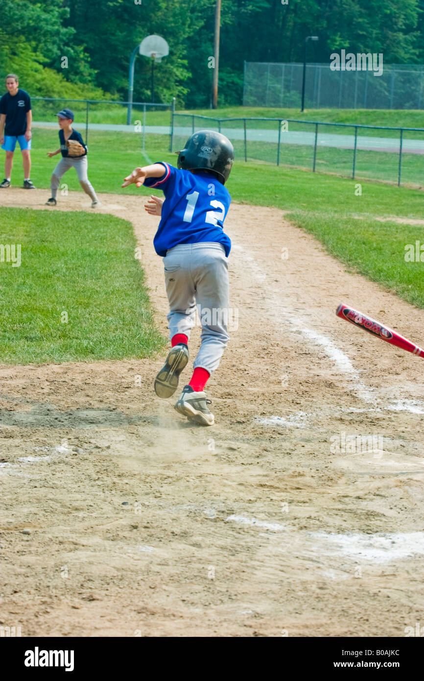 Young boy the batter running to first base during a Little League