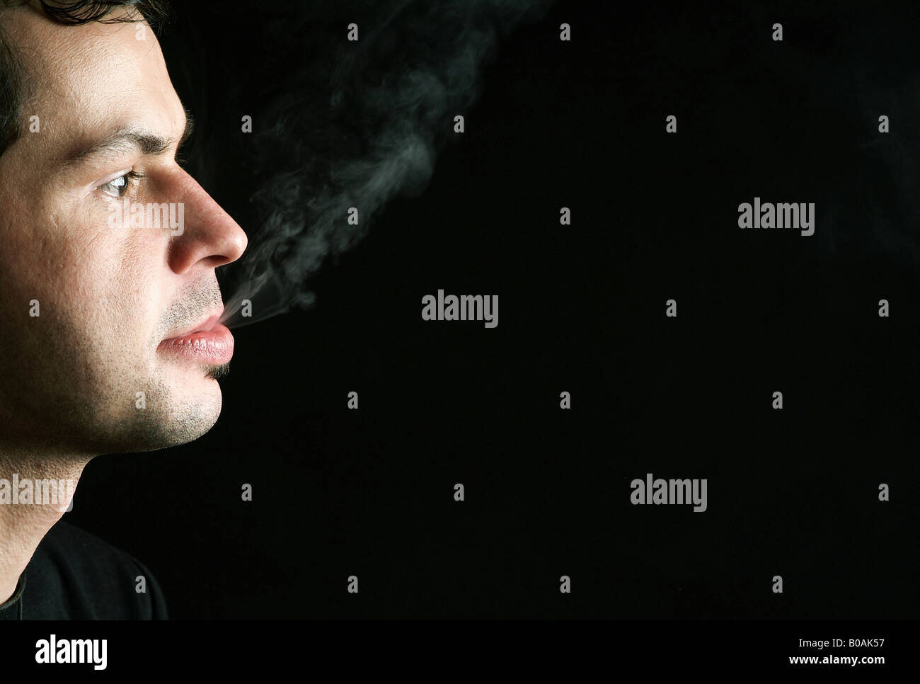 Man exhaling cigarette smoke Stock Photo