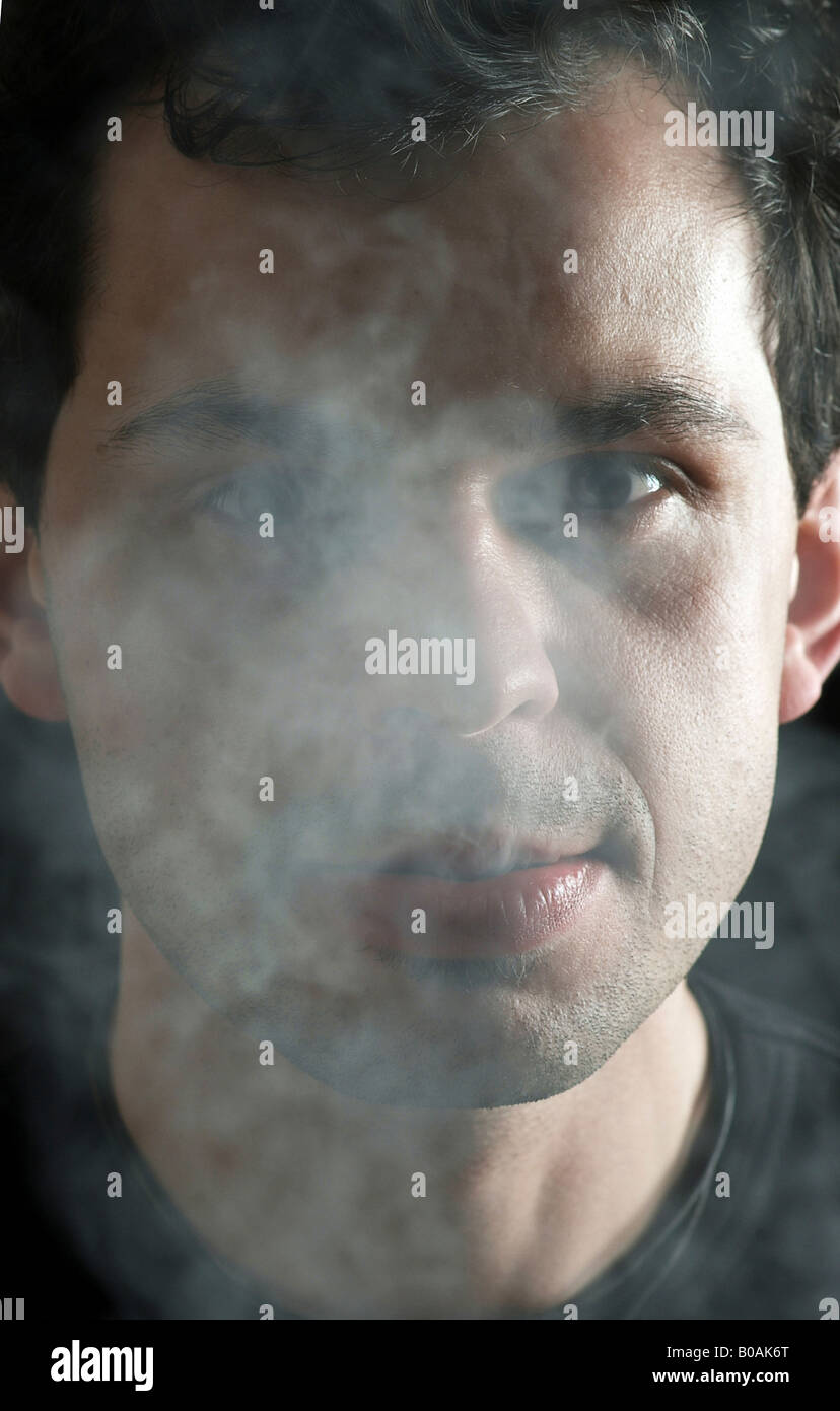 Man exhaling cigarette smoke Stock Photo