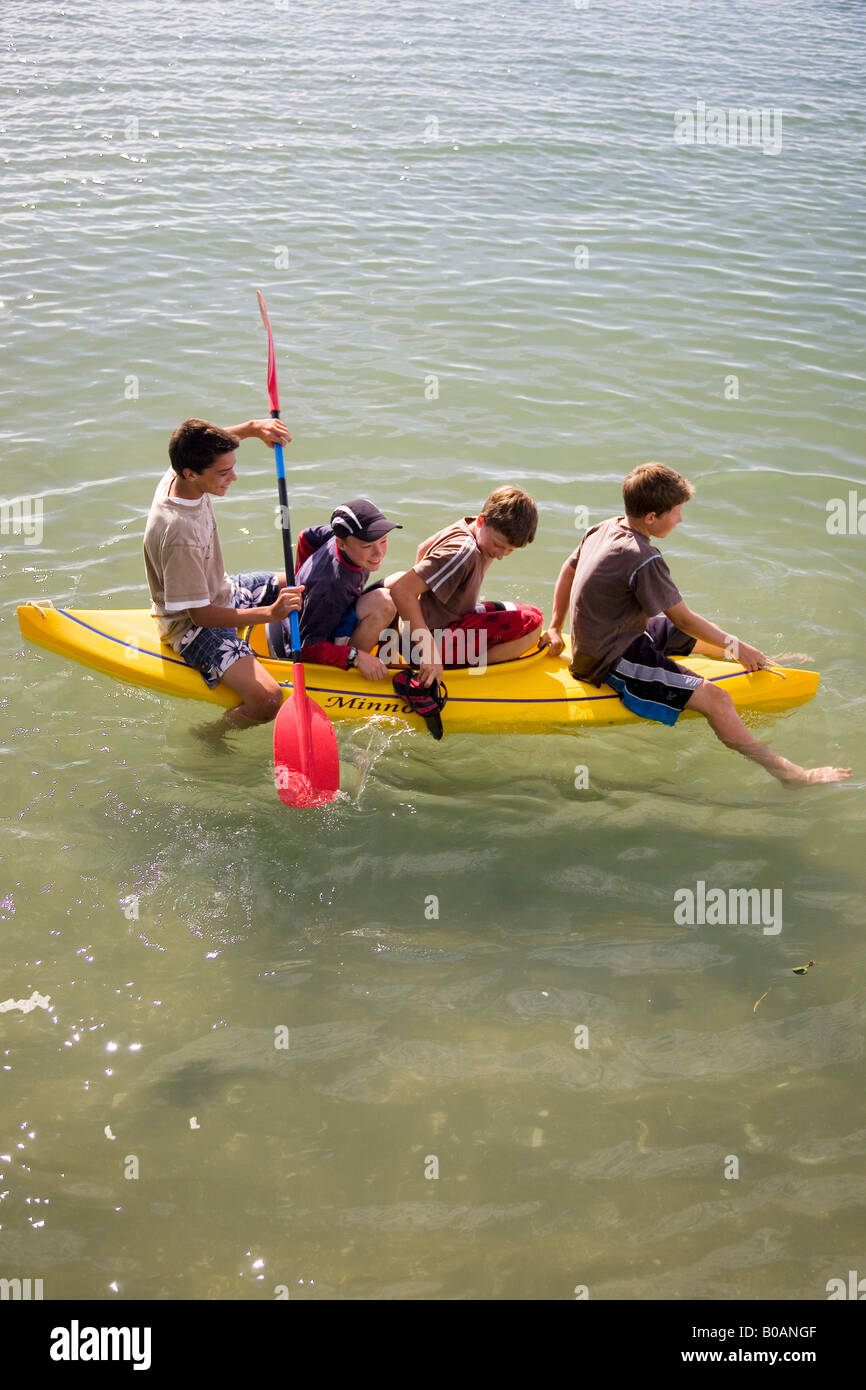 4 Kids goofing off in a kayak Stock Photo