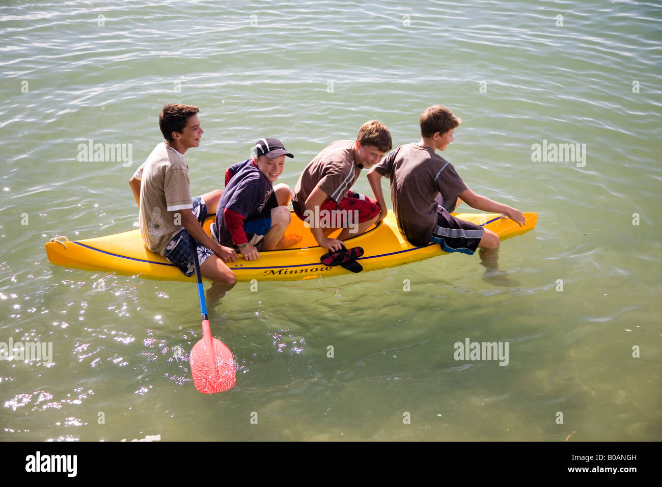 4 Kids goofing off in a kayak H Stock Photo